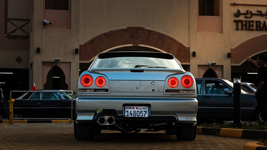 A Nissan GTR parked outside a traditional building in Bahrain, showcasing its iconic taillights.